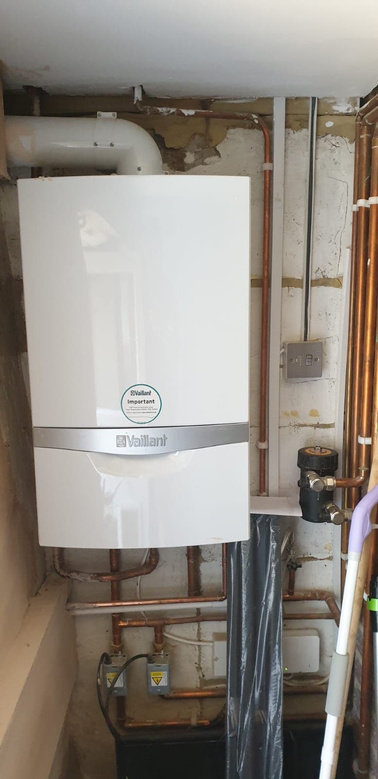Wall-mounted gas boiler installation with neat pipework