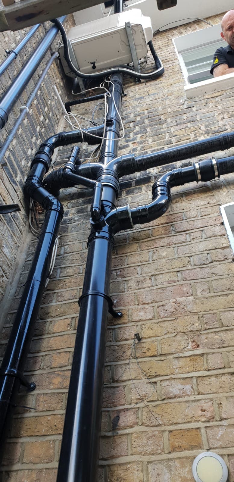 Heating system pipework neatly run against brickwork